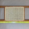 A wooden tray with a white woven pattern on it.