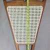 A wooden chair with a white seat and green handle.