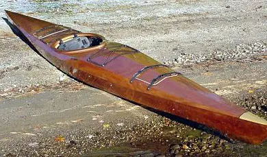 A wooden canoe sitting on top of the water.