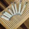 A table with nine white toothbrushes on it.