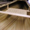 A wooden bench with a cane seat on top of it.