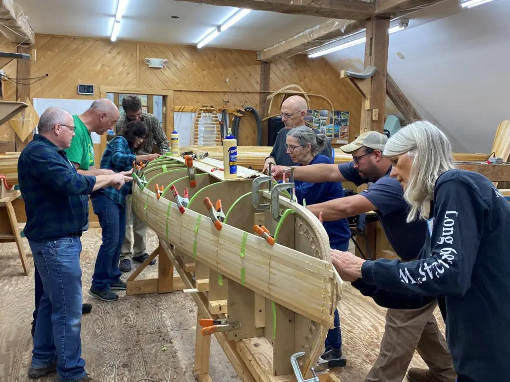 A group of people working on wooden boats.
