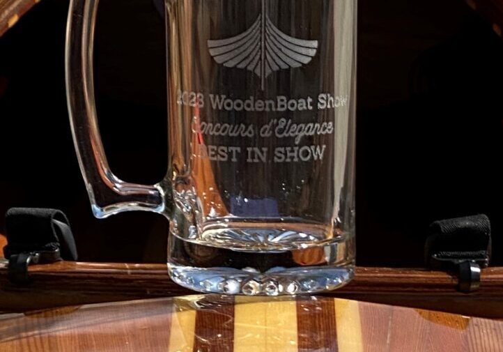 A beer mug sitting on top of a wooden barrel.