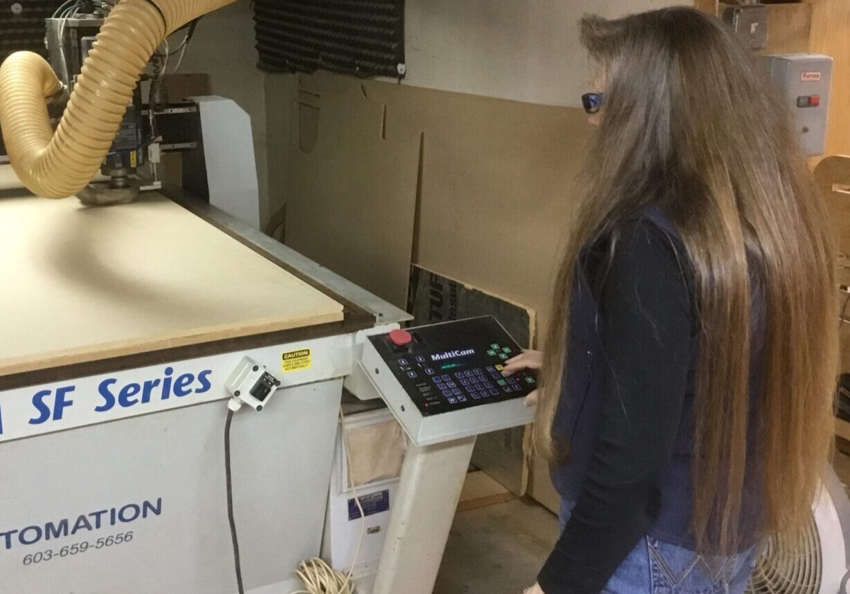 A woman standing in front of a machine.