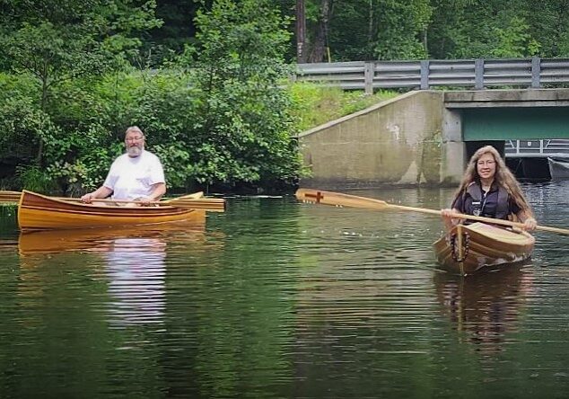 Two people in a boat on the water.