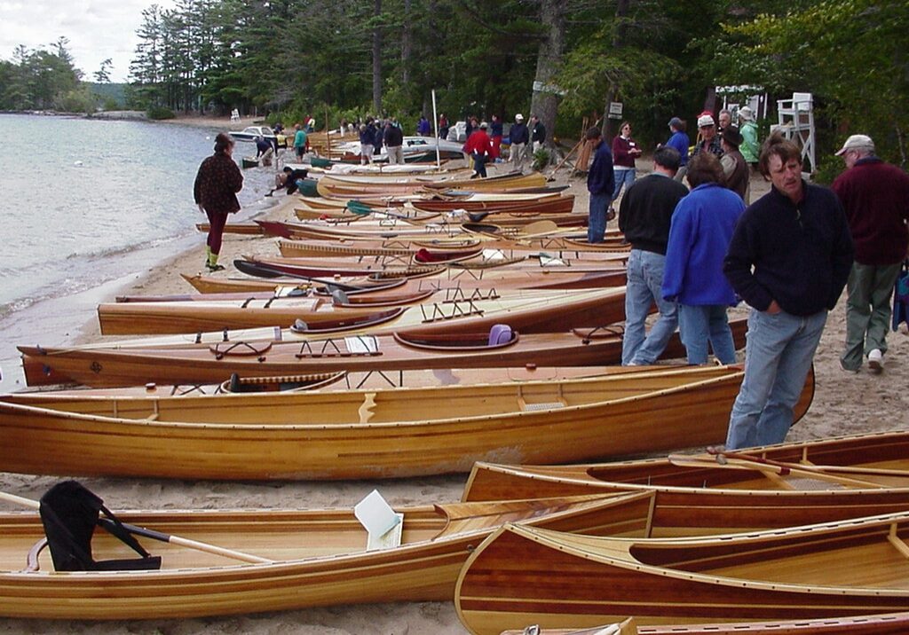 A group of people standing around many small boats