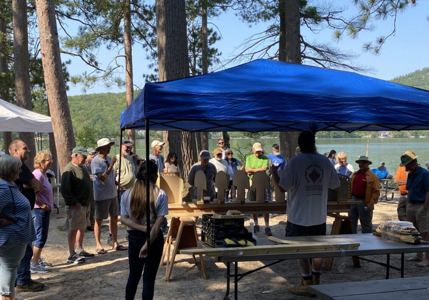 A group of people gathered under a blue tent.